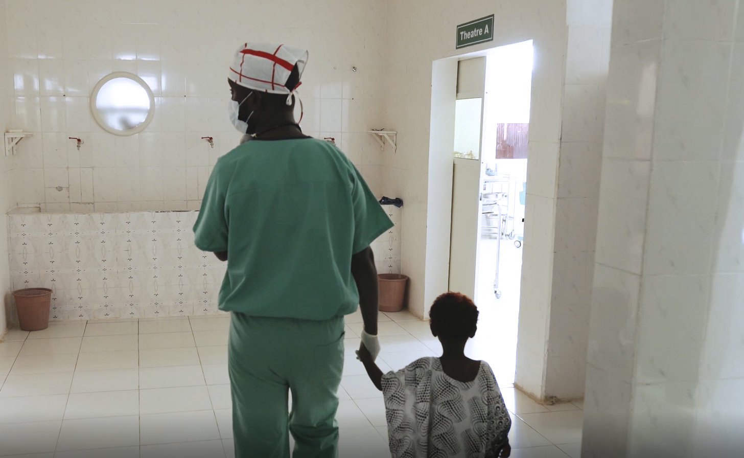 Medical staff member walking with child